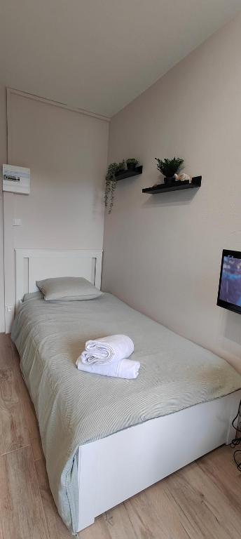 une chambre avec un lit avec deux serviettes dessus dans l'établissement Votre Refuge Urbain Logement Complet pour Étudiants et Pros, à Rennes