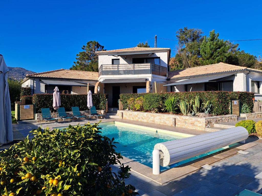 une maison avec une piscine devant une maison dans l'établissement côte et mer - appartement haut standing dans villa avec piscine et vue mer, à Taglio-Isolaccio