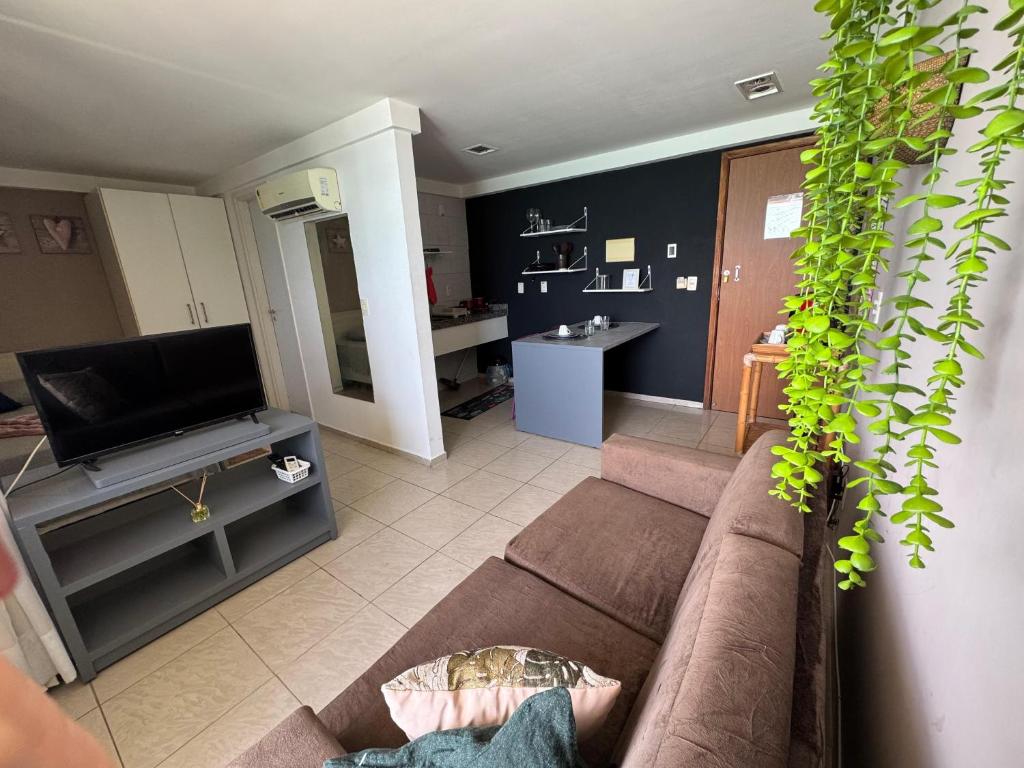 a living room with a couch and a tv at Frente Mar in Natal