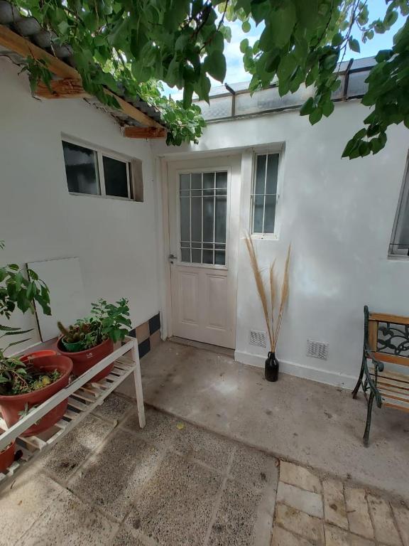 a white door of a house with potted plants at brisa azul in General Roca