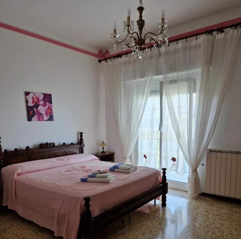 sypialnia z łóżkiem z żyrandolem i oknem w obiekcie B&B Mare e Monti w mieście La Spezia