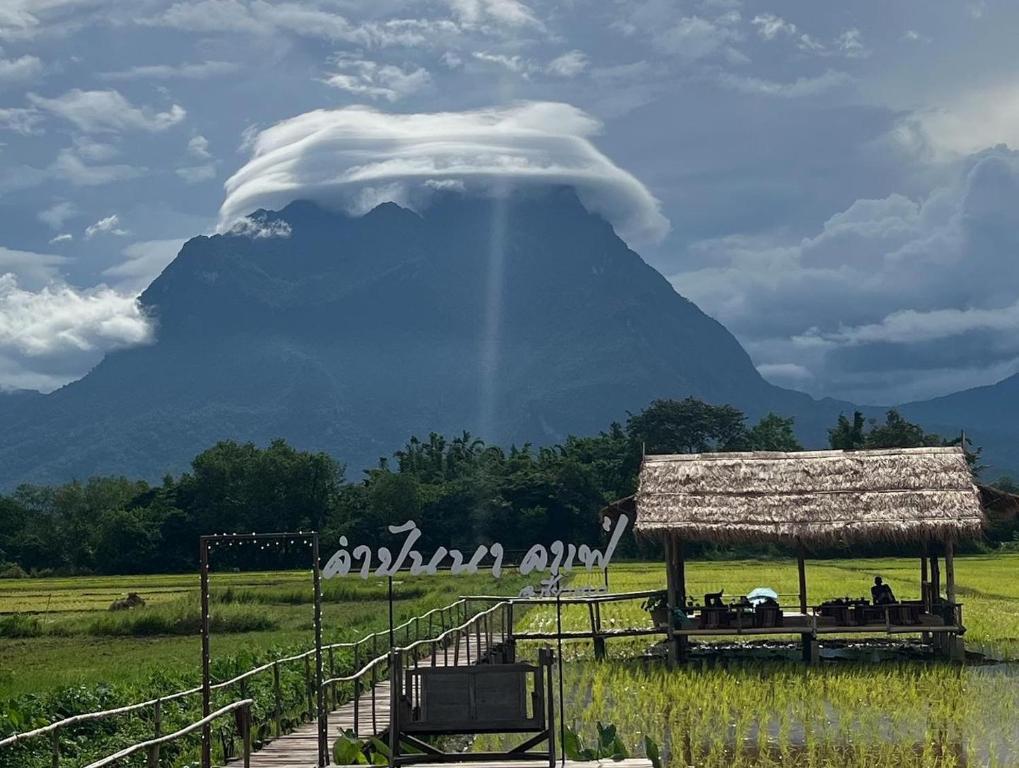 un nuage au-dessus d'une montagne avec une cabane dans un champ dans l'établissement Khampanna Cafe' resort & Nature, à Ban Sop Nong