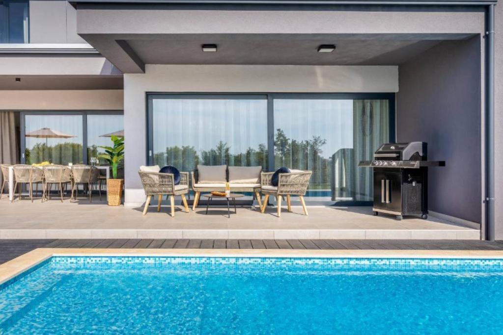 Casa con piscina, mesa y parrilla en Elegant Villa With Pool And Sauna, en Raša