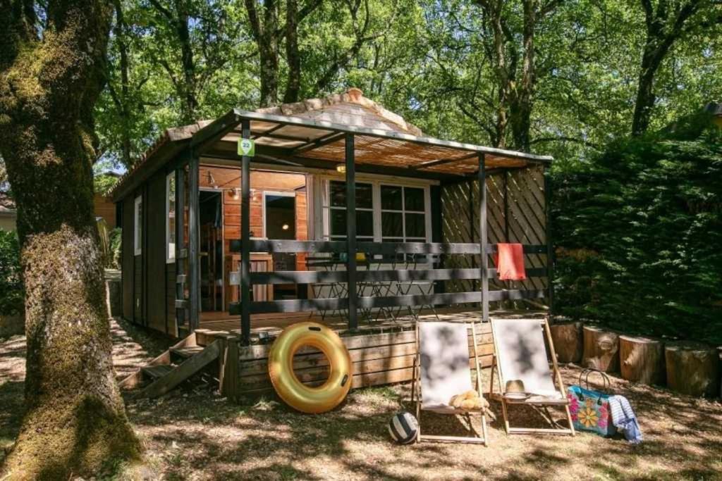 una piccola casa con due sedie e un albero di Chalet 4 étoiles - Piscine - ccafdif a Loupiac