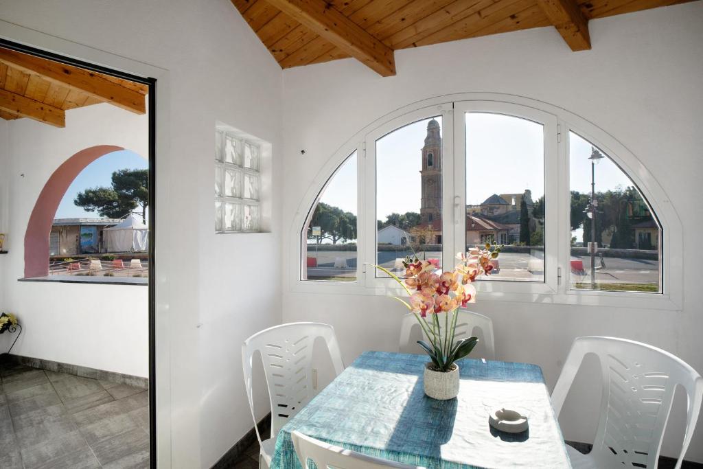 Casa bici sole e mare في سان لورينزو الماري: غرفة طعام مع طاولة مع إناء من الزهور
