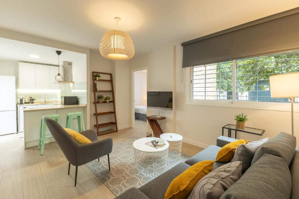 a living room with a couch and a table at Charming Apartment with private patio at Plaza de España by OCityzen in Seville