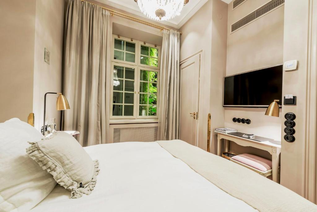 una camera da letto con un letto bianco e una televisione di Hotel Kungsträdgården a Stoccolma
