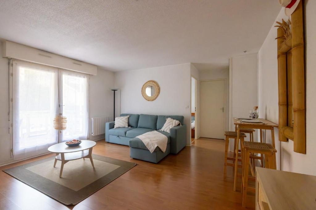 un salon avec un canapé bleu et une table dans l'établissement Parenthèse de bonheur - 600 m de la plage, à Arcachon