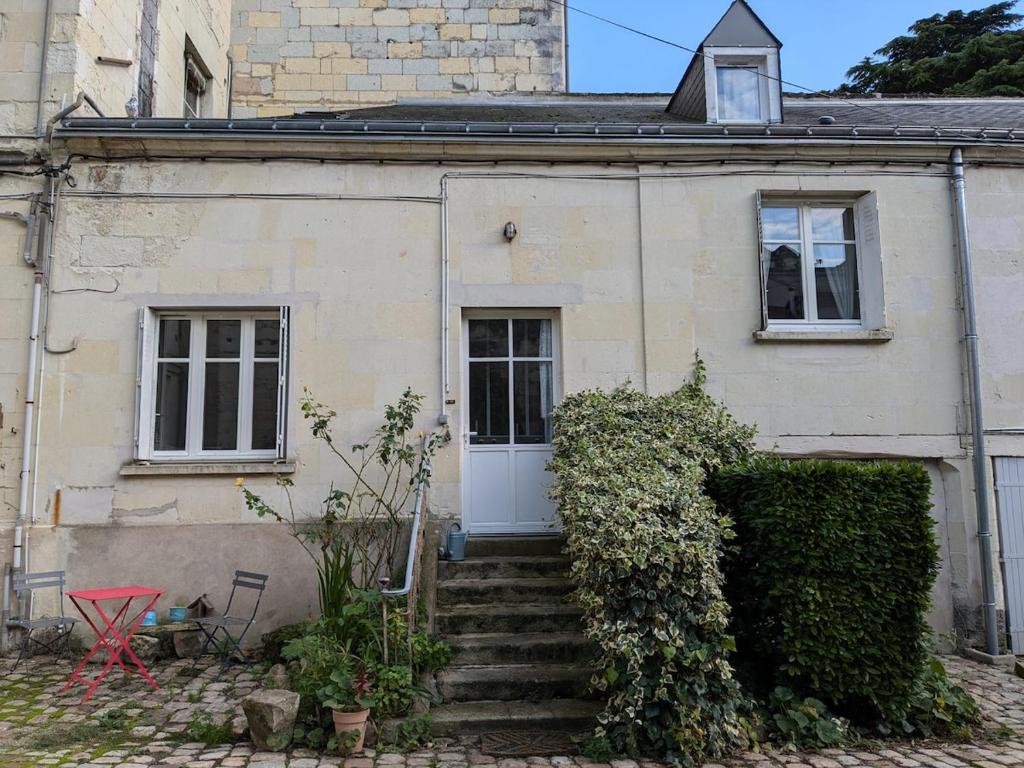 une maison ancienne avec une porte blanche et des escaliers dans l'établissement T2 Au pied du château sans vis à vis, à Saumur
