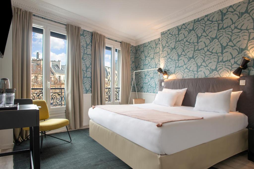 a hotel room with a large bed and a window at Hôtel Avama Prony in Paris