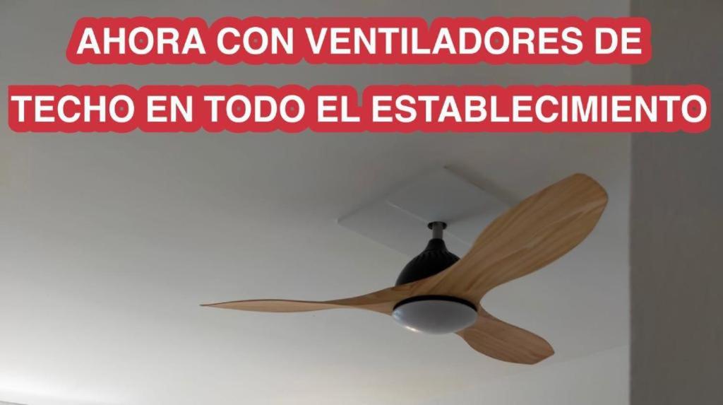 a wooden ceiling fan in a room with a sign at Apartamentos Eldorado in Lloret de Mar