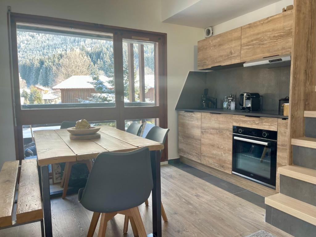 une cuisine avec une table en bois et une salle à manger dans l'établissement Le Marlotte, aux Carroz d'Arâches