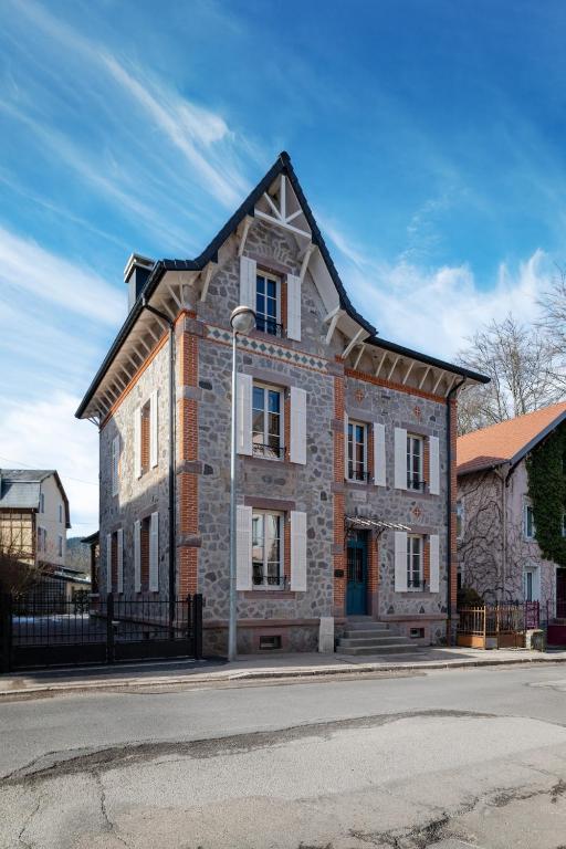 un vieux bâtiment en briques au bord d'une rue dans l'établissement Villa Les V-iolettes proche lac et centre ville, spa, à Gérardmer