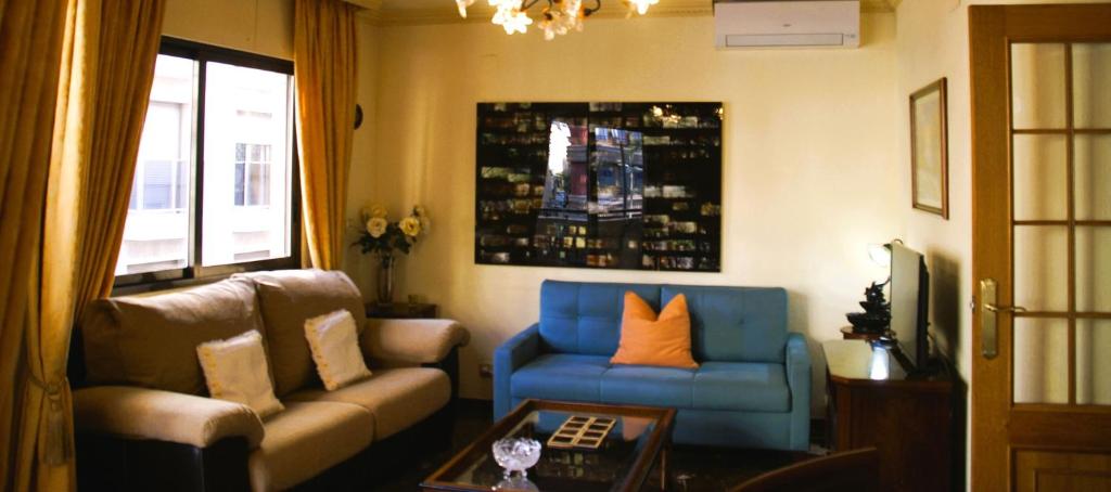 Una sala de estar con un sofá y una silla azul. en Microclimate Center, en Alicante
