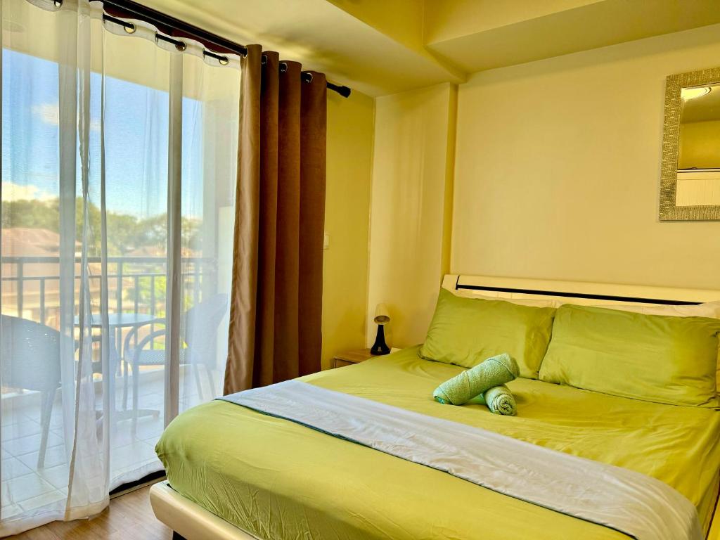 a bedroom with a yellow bed with a balcony at Tagaytay Staycation - Kasa Luntian in Tagaytay
