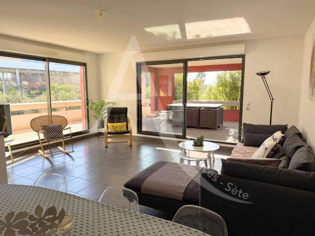 un salon avec un canapé et une table dans l'établissement 3 CHAMBRES TOUT CONFORT EN BORD DE MER, à Sète