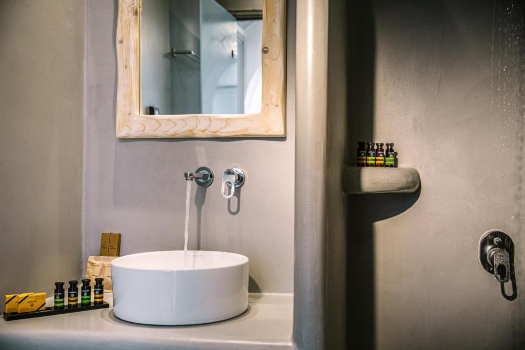 a bathroom with a white sink and a mirror at Kalisti Hotel & Suites in Fira