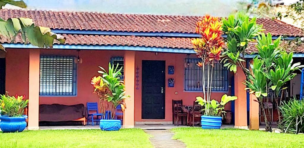 a red house with palm trees in front of it at Casa Jardim do Mar - Ubatuba - Praia Grande in Ubatuba