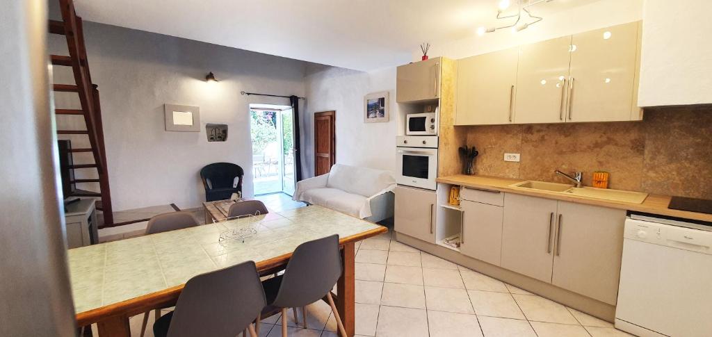 a kitchen with a table and chairs in a room at Maison typique corse pour 4 personnes in Zonza