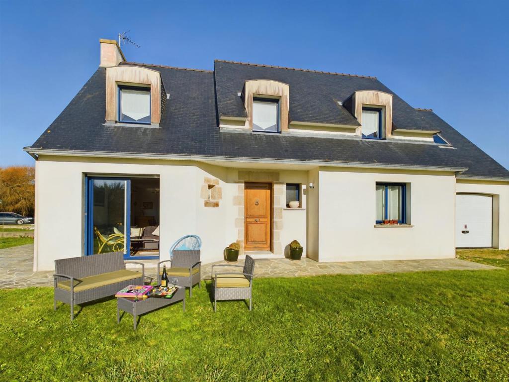 une maison blanche avec une pelouse devant dans l'établissement Penmarch Kerity, maison pour 9 avec jardin, à Penmarcʼh