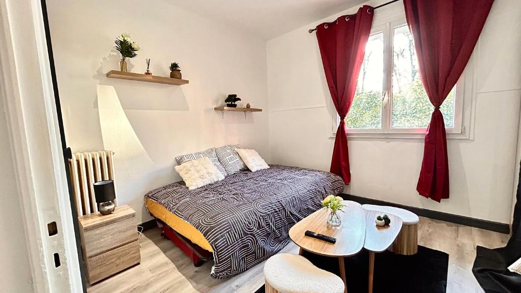 une chambre avec un lit, une table et une fenêtre dans l'établissement Studio cosy Aix les Bains, à Aix-les-Bains