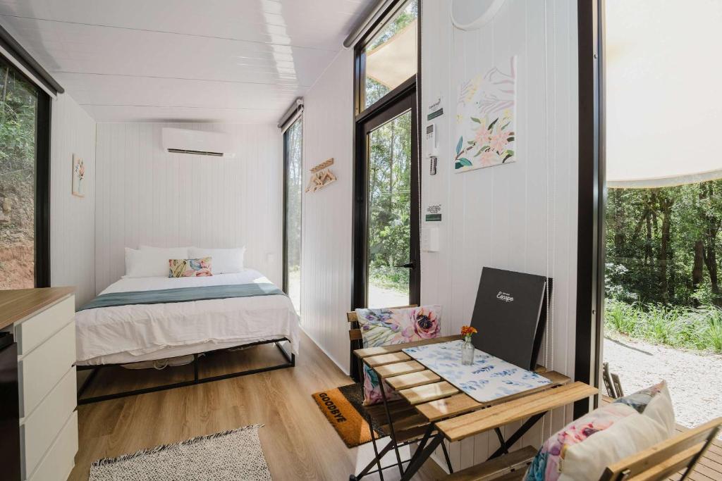 una piccola camera con letto e tavolo di Raspberry Spring Corner by Tiny Away a Clothiers Creek