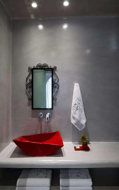 a bathroom with a red sink and a mirror at Kalisti Hotel & Suites in Fira