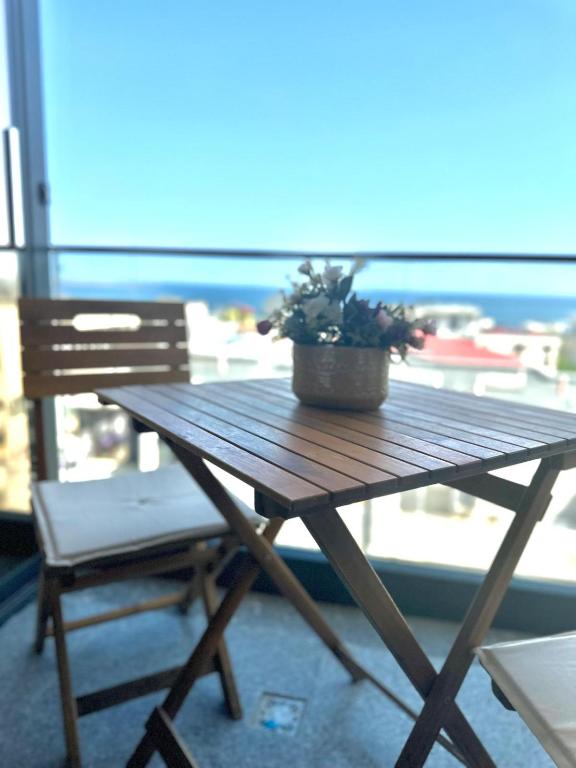 a wooden table with a potted plant on a balcony at Apartamente & Studiouri Melia Eforie Nord in Eforie Nord