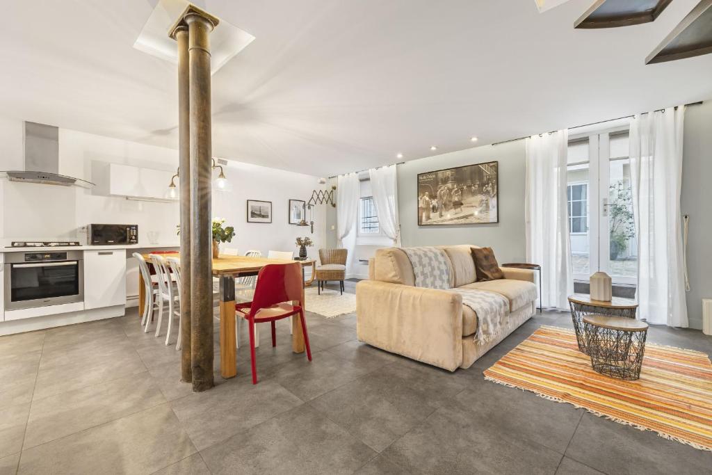 un salon avec un canapé, une table et une cuisine dans l'établissement Bahia, à Paris