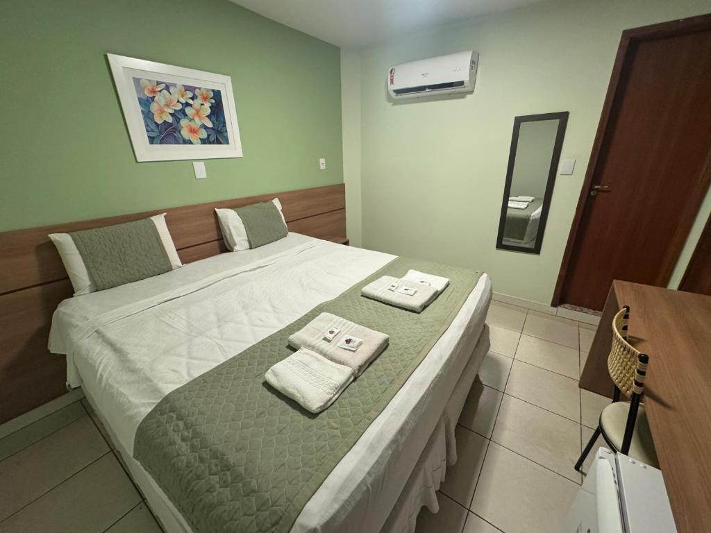 a bedroom with a bed with two towels on it at Domus Hotel Veneza - Ipatinga in Ipatinga