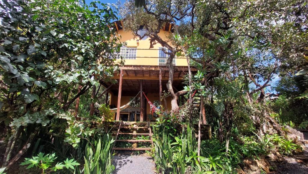 a house surrounded by trees and plants at Chalet Ecológico Pantoja in Alto Paraíso de Goiás