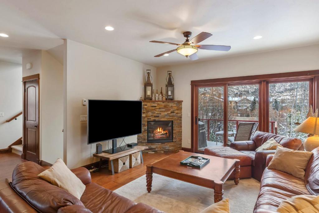 a living room with couches and a tv and a fireplace at Majestic Getaway in Steubenville