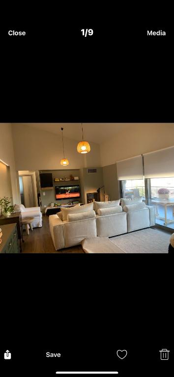 a living room with white couches and a living room with a couch at Ourania26! in Glyka Nera