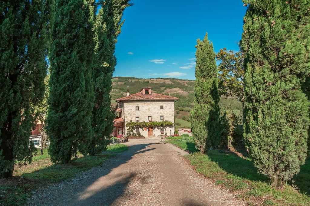 una casa en medio de una carretera con árboles en Fattoria Ca' di Fatino, en Castiglione dei Pepoli