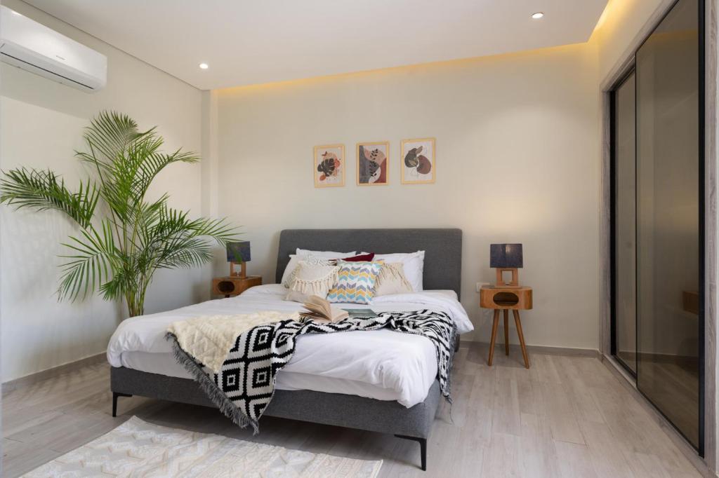 Un dormitorio con una cama y una planta en maceta. en Degla by Spacey #37 - 1BR in Maadi, en El Cairo