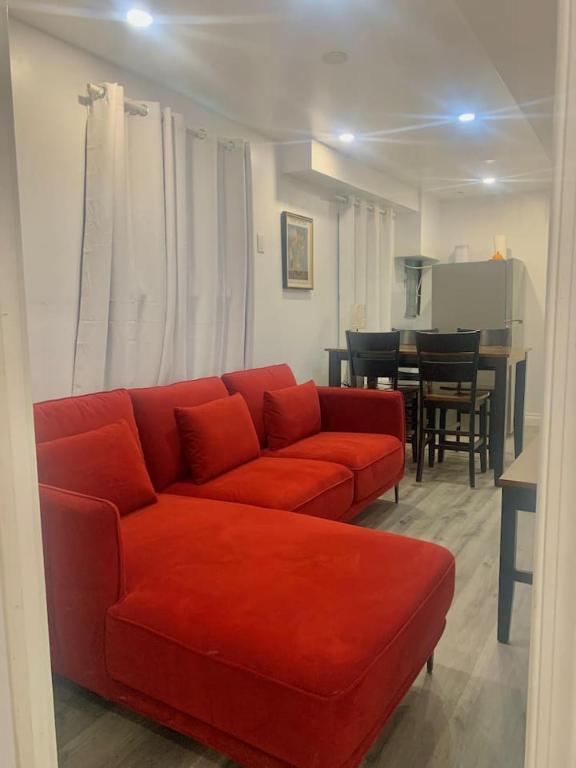 a living room with a red couch and a table at Cozy 2BR1BA apt in SilverSpeing in Silver Spring