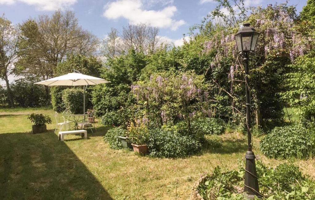 un lampadaire dans un jardin avec un parasol dans l'établissement Stunning Home In Touvois With Wifi, à Touvois