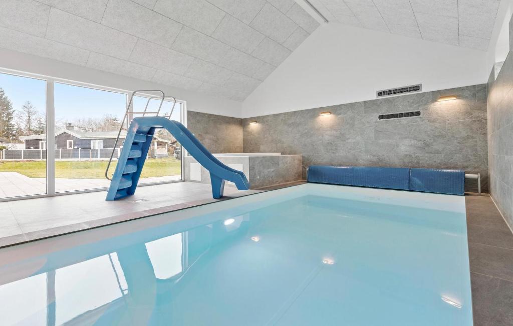 a swimming pool with a slide in a building at Gorgeous Home In Glesborg With Sauna in Glesborg