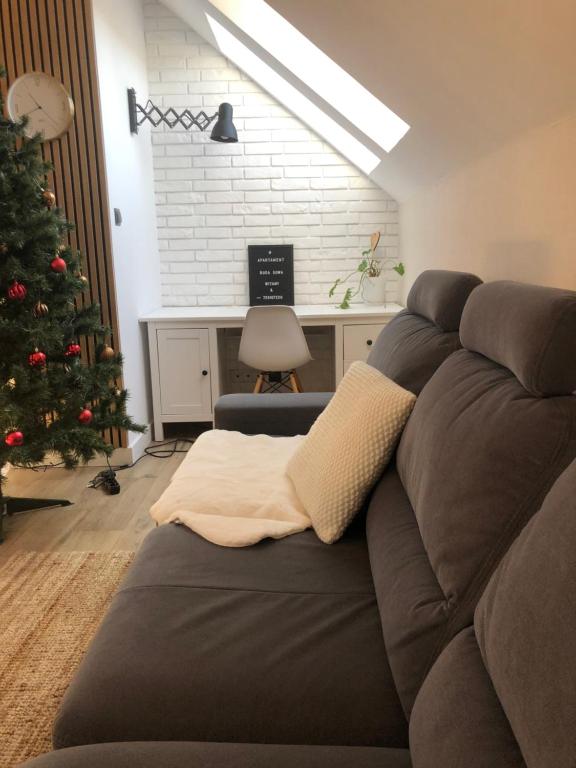 a living room with a christmas tree and a couch at Skandi Apartament in Nowa Ruda