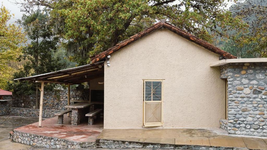 a small white house with a stone wall at ESTANCIA CASA DE PIEDRA casa 1 in San Isidro
