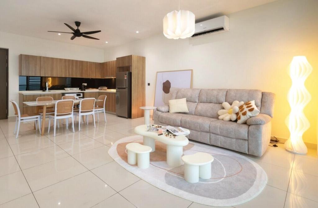 a living room with a couch and a table at Sea View Cozy 2BR Green Haven -Permas Masai CIQ -7 to 9pax in Masai
