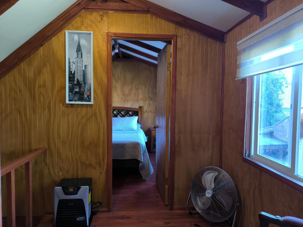 a bedroom with a bed and a fan in a room at Cabaña Villa Reina Sofia in Valdivia