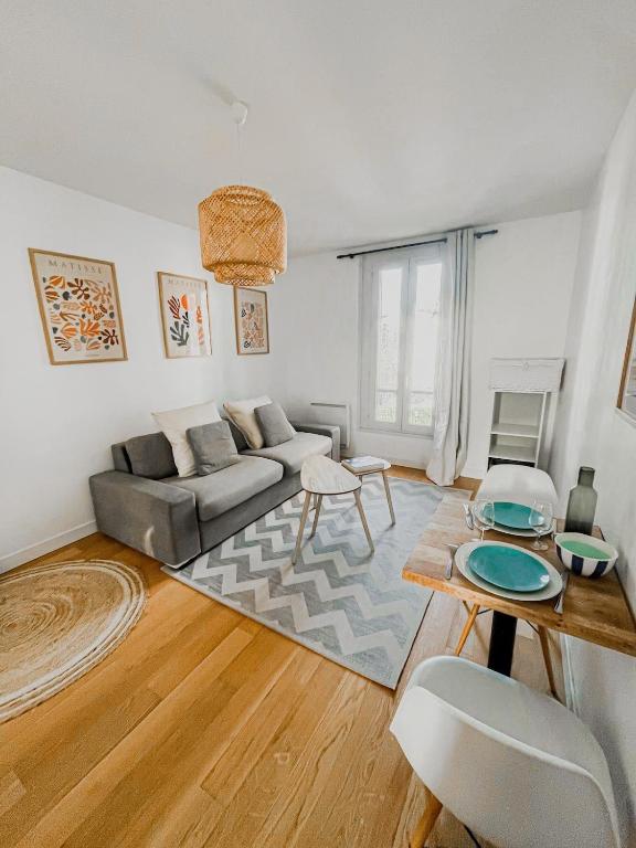 un salon avec un canapé et une table dans l'établissement Studio équipé St cloud proche Paris - La Défense, à Saint-Cloud