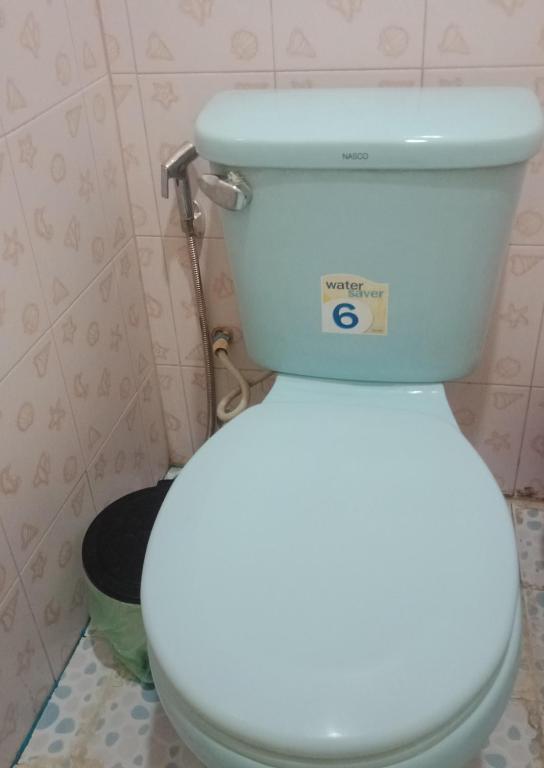 a bathroom with a toilet with a sign on it at มังกรเลโฮสเทล Mangkonlay Hostel in Ban Khlong Pak