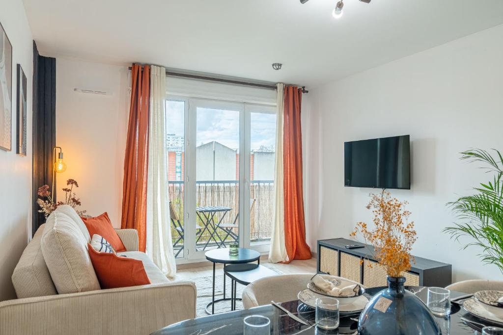 un salon avec un canapé et une table dans l'établissement Les ailes du vent - 10min Paris - Parking, à Montreuil