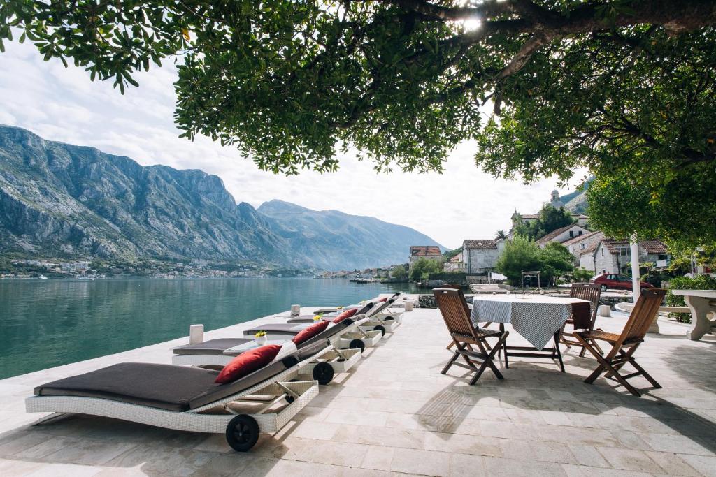 a row of chaise lounges on the side of a lake at Art Hotel Galathea in Kotor