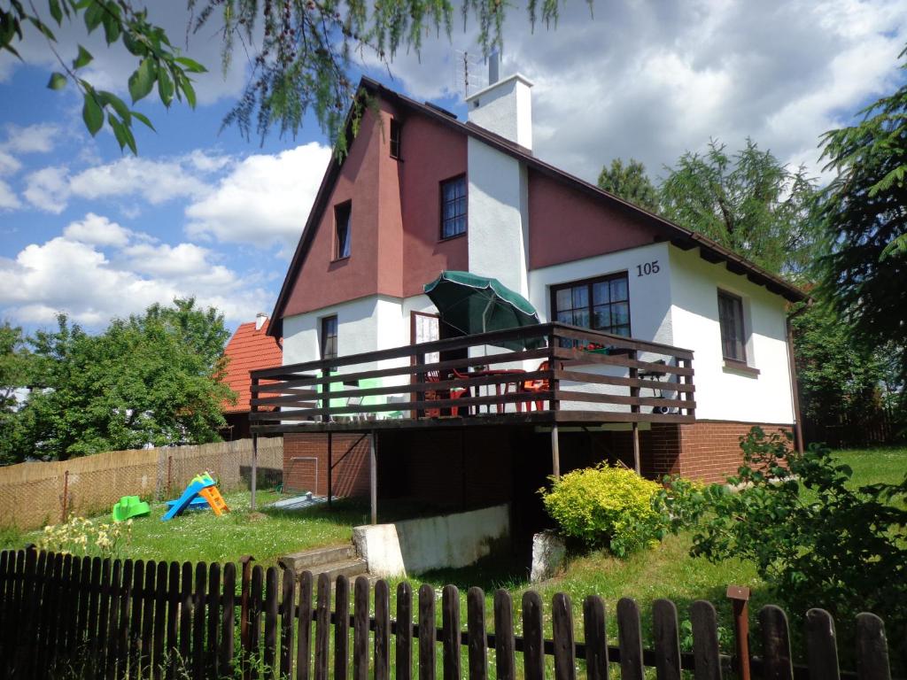 una casa grande con una valla delante en Domek Letniskowy nad Jeziorem Tumiany, en Bartołty Wielkie