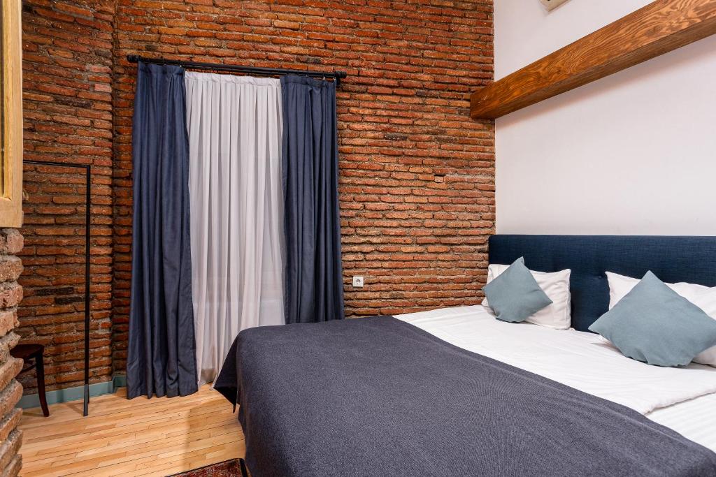 Postel nebo postele na pokoji v ubytování Ethnograph Hotel old Tbilisi