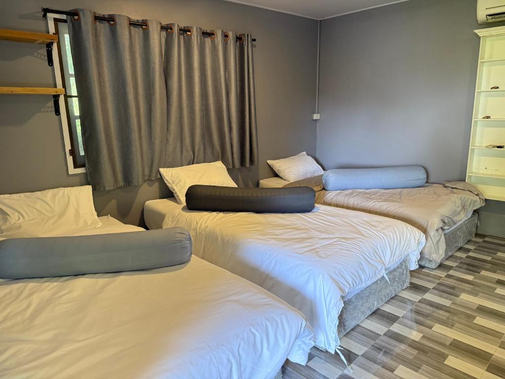 a room with four beds in a room at บ้านเชิงเขาโฮมสเตย์ บ้านบนเขา in Ban Mai