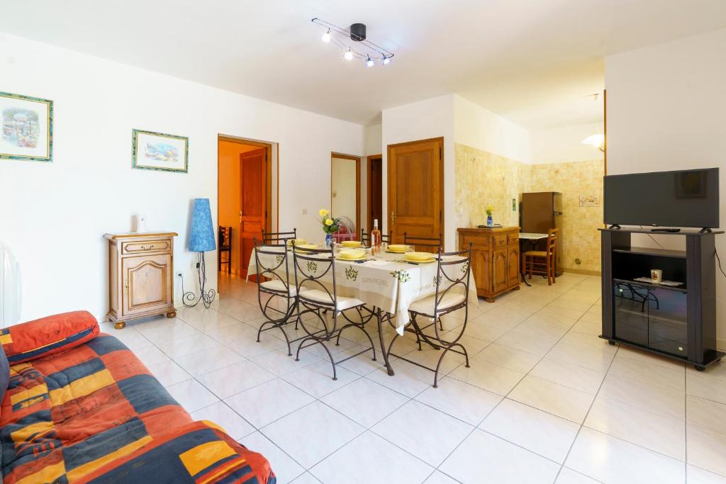 - un salon avec une cuisine et une table avec des chaises dans l'établissement La Caletta Corsa Apartments con due camere a 100 m dal mare - WiFi fibra FTTH - ALL INCLUSIVE, à Linguizzetta